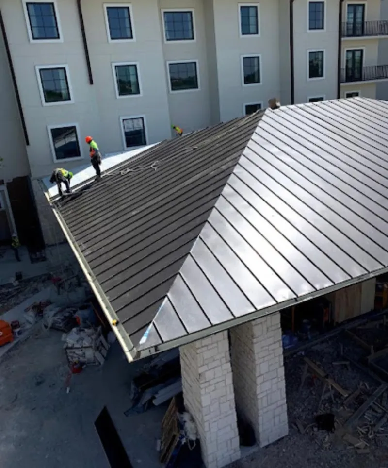 Crew installing standing seam metal roof panels on a commercial project in Park City